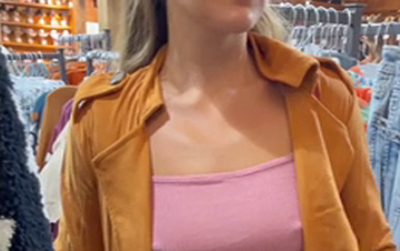 Exhibicionista enseñando el coño y las tetas duras en una tienda